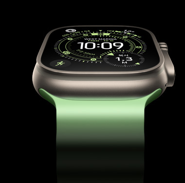 검은색 배경에 있는 내추럴 티타늄 Apple Watch Ultra 3를 클로즈업해서 보여주는 모습. 디스플레이에 시간과 기타 동적 정보가 표시되어 있습니다.